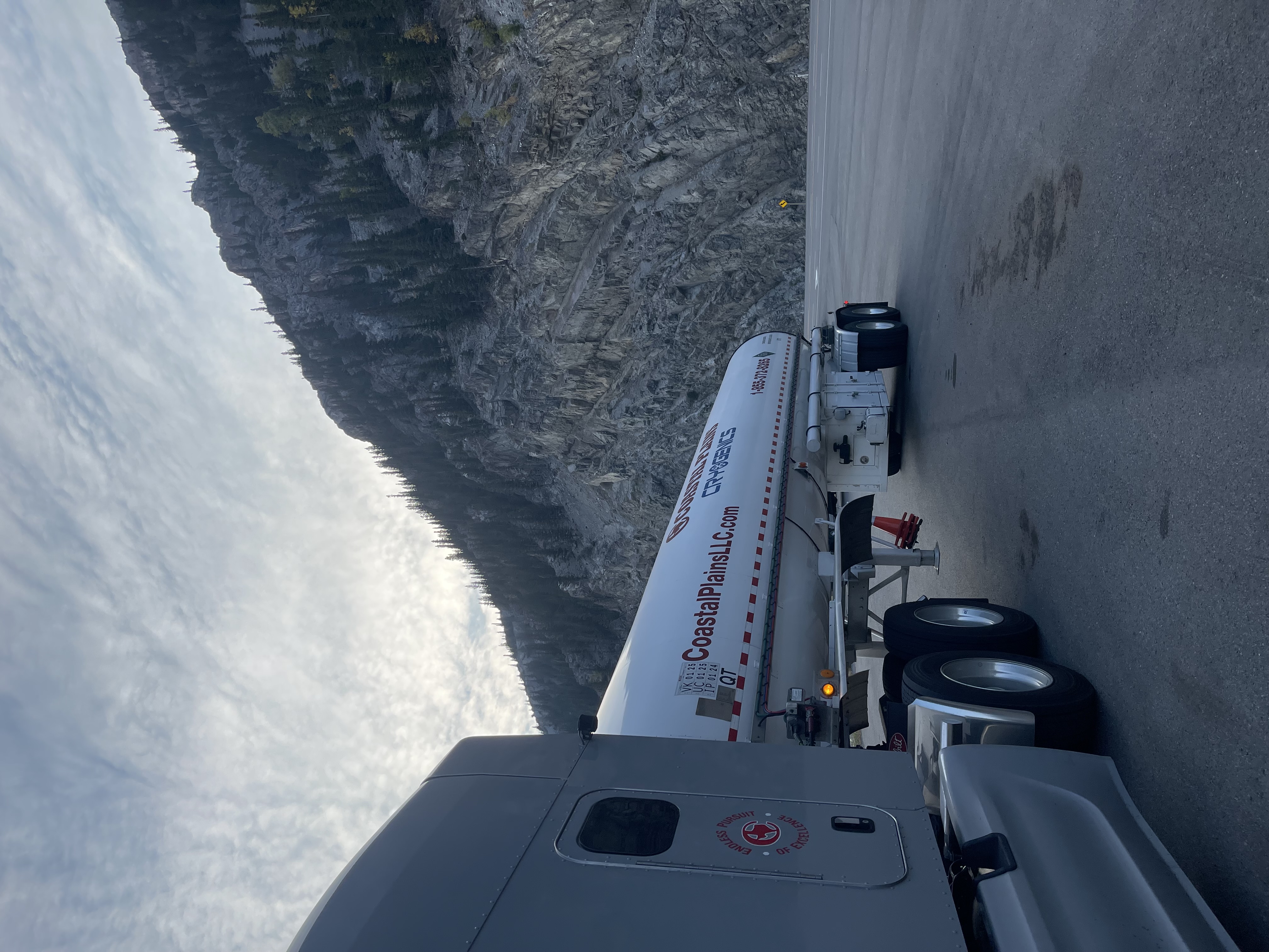 Coastal Plains Trucking truck is parked alongside a mountain in Canada.